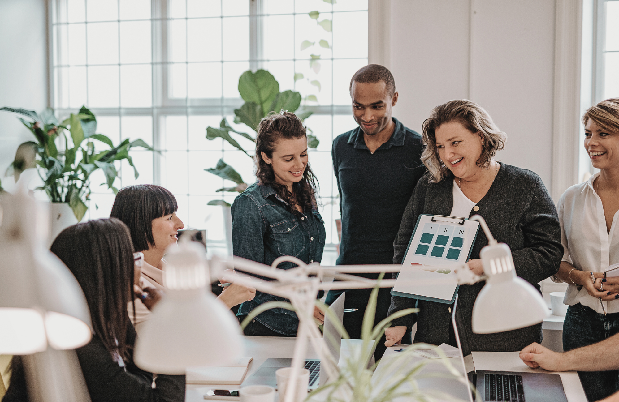 team gathered around office sharing impact results with employees