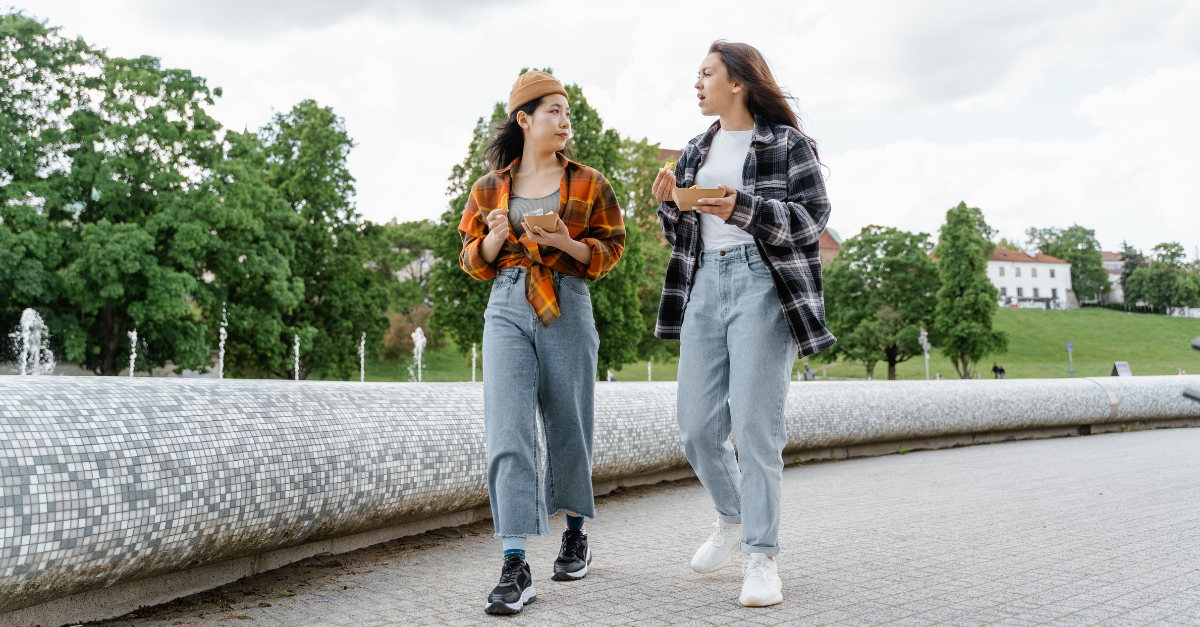 Girls walking in park with food from local food vendor